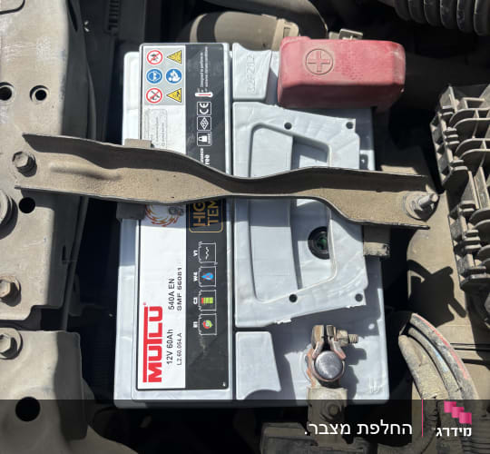 מצבר רכב מותקן בתא מנוע עם חיבורים חשמליים